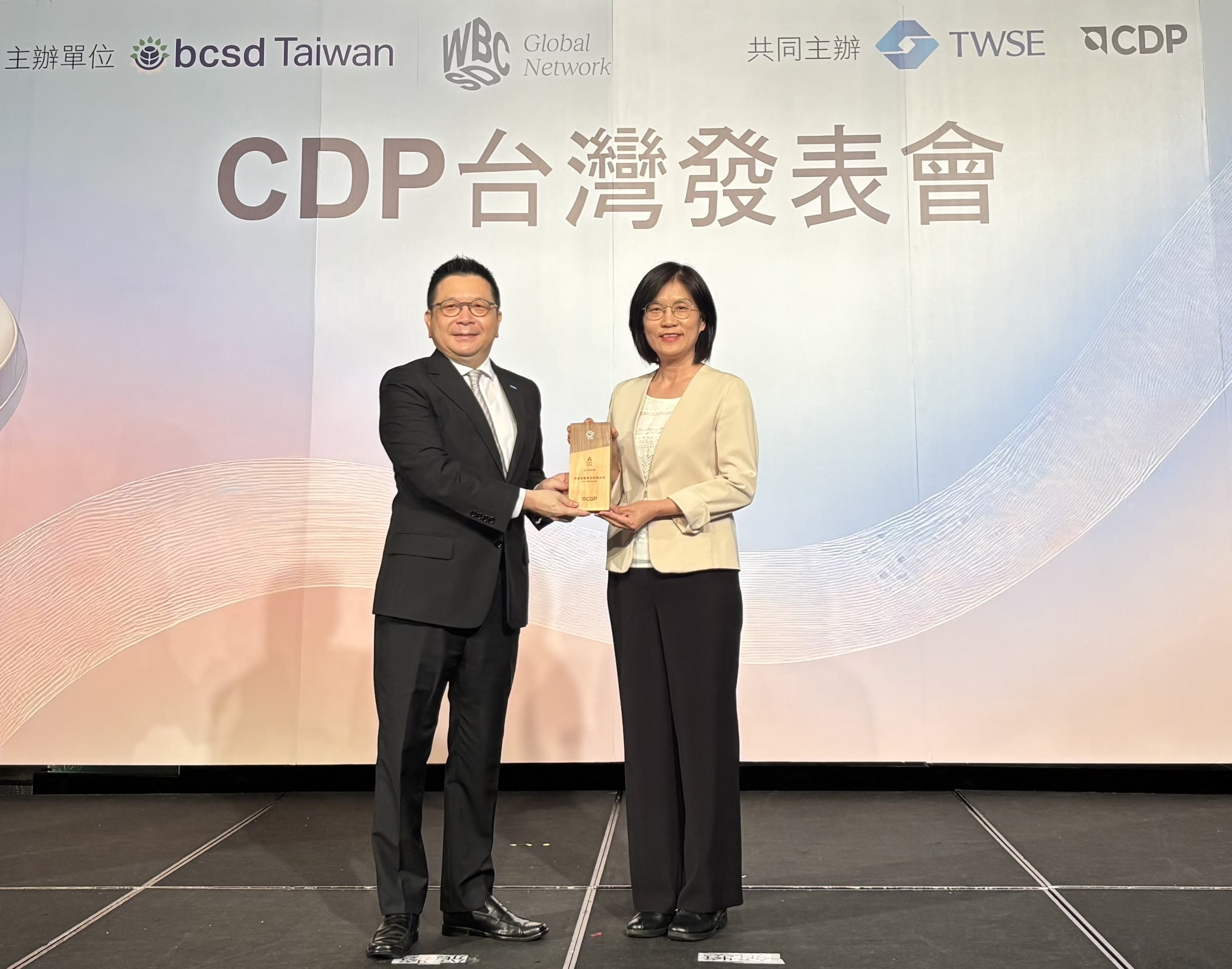 友達永續成果再獲國際評比肯定，獲頒CDP氣候與水資源雙項領導力評級。今由臺灣證券交易所董事長林修銘（左）頒獎，友達光電永續長古秀華（右）代表受獎